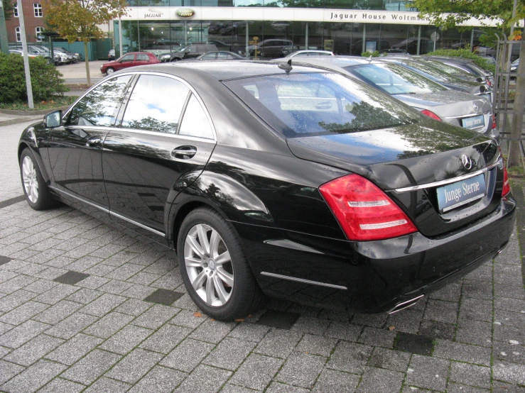 a black mercedes benz s350 is parked in front of a dealership