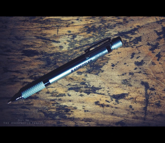 a pen is laying on a wooden surface