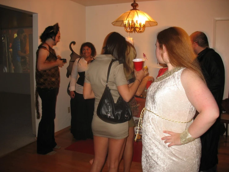 a group of women are gathered around drinking coffee