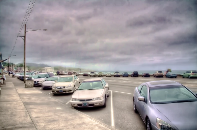 a bunch of cars in a parking lot by a bus stop