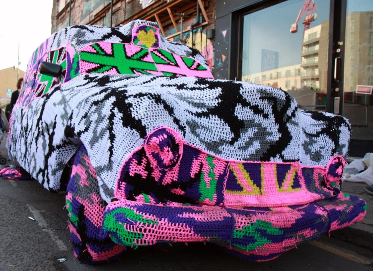 a crocheted car that has been placed on the street