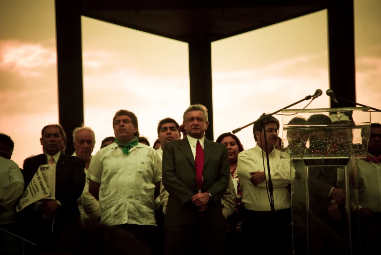 several men are in front of microphones and one is speaking