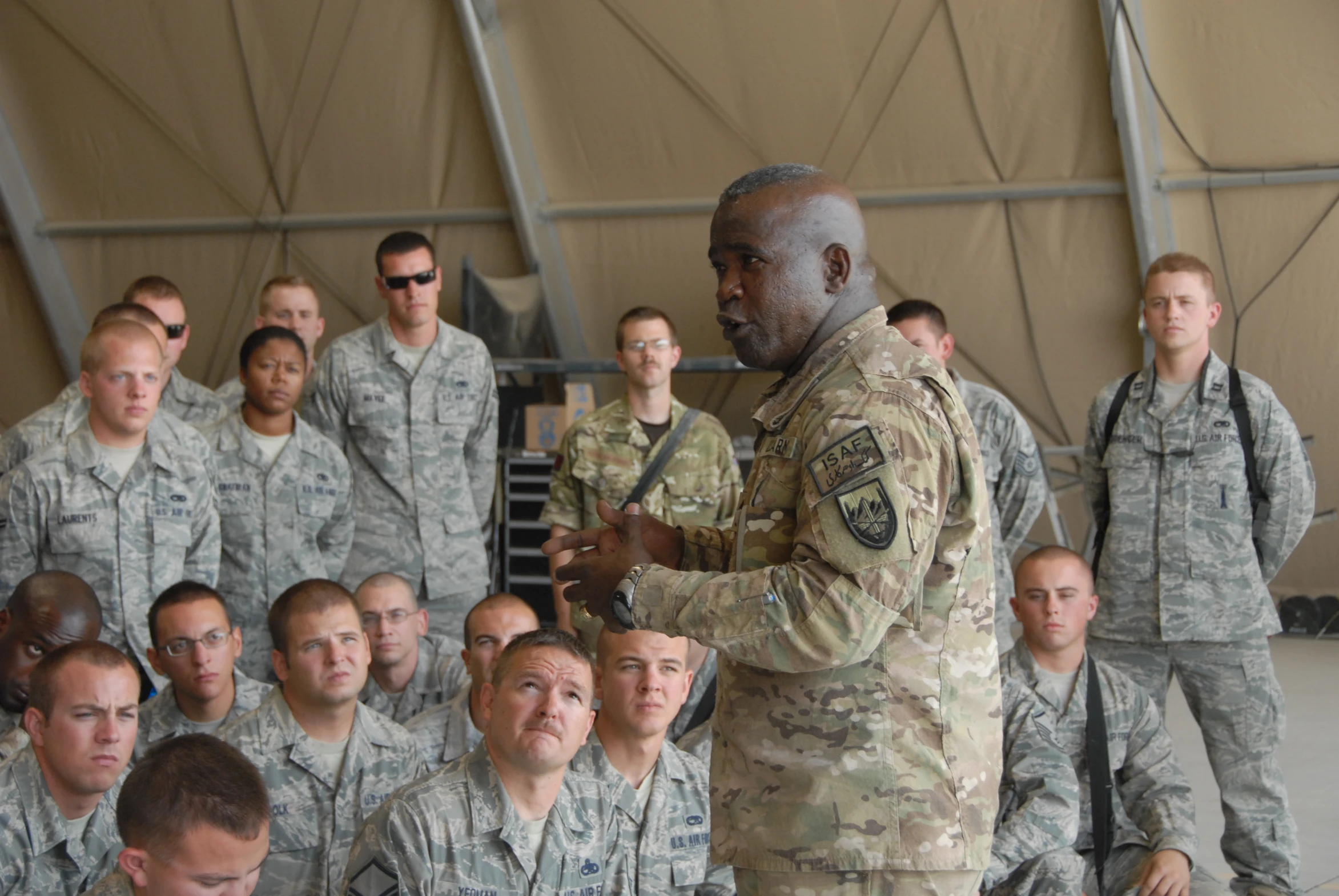 a man in military uniform standing near a group of soldiers