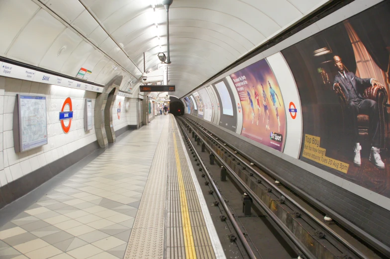 a subway station with several different colored posters