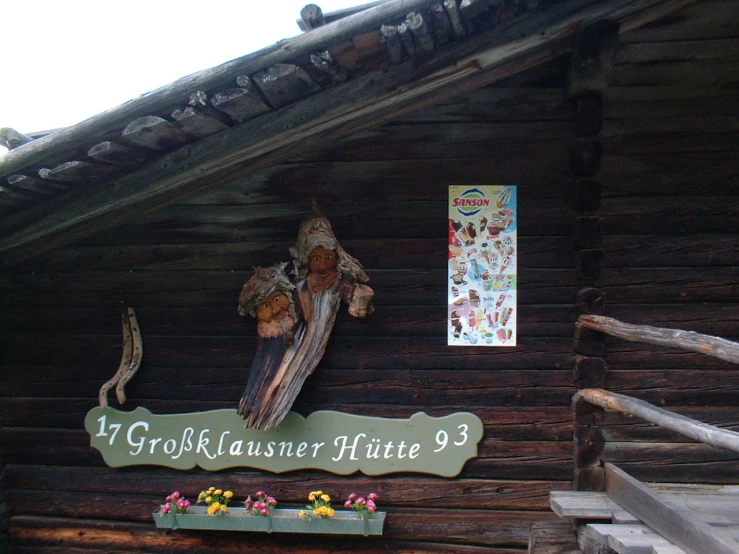an old wooden building with signs hanging from it