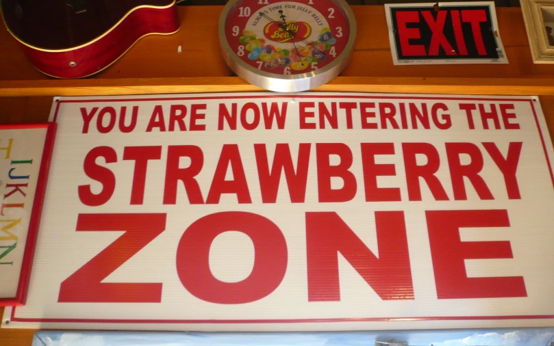 the sign is in front of the clock says, you are now entering the strawberry zone
