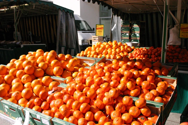 an outdoor fruit stand filled with lots of oranges