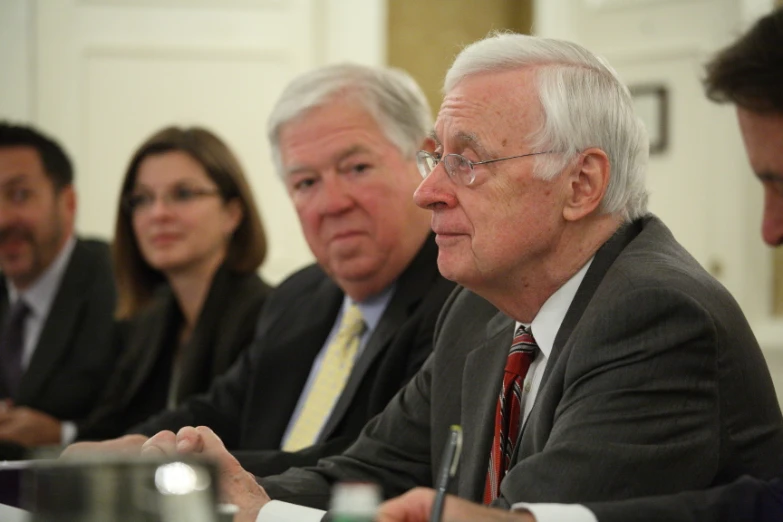 four business people in suits sitting at a table