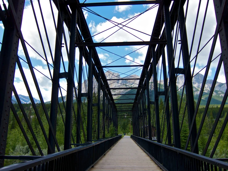 a wooden bridge has the path leading to the mountain