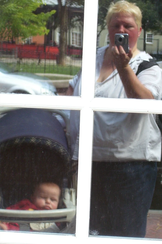 man in white shirt taking selfie through multiple windows