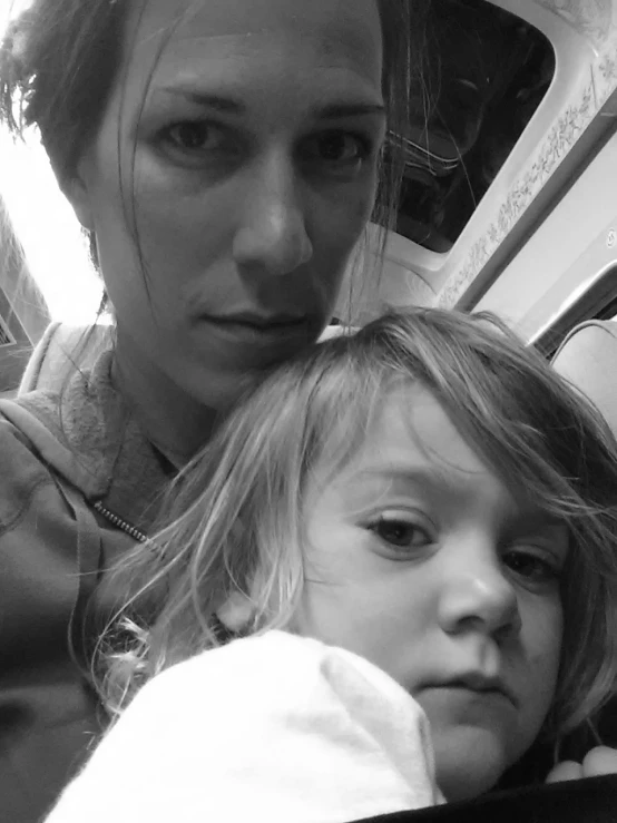 a young woman holds her daughter on a bus