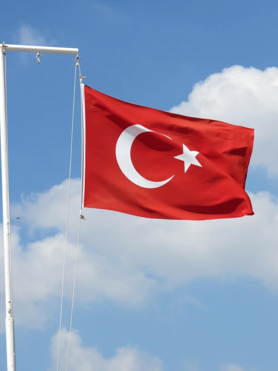 a turkish flag is flying high in the sky