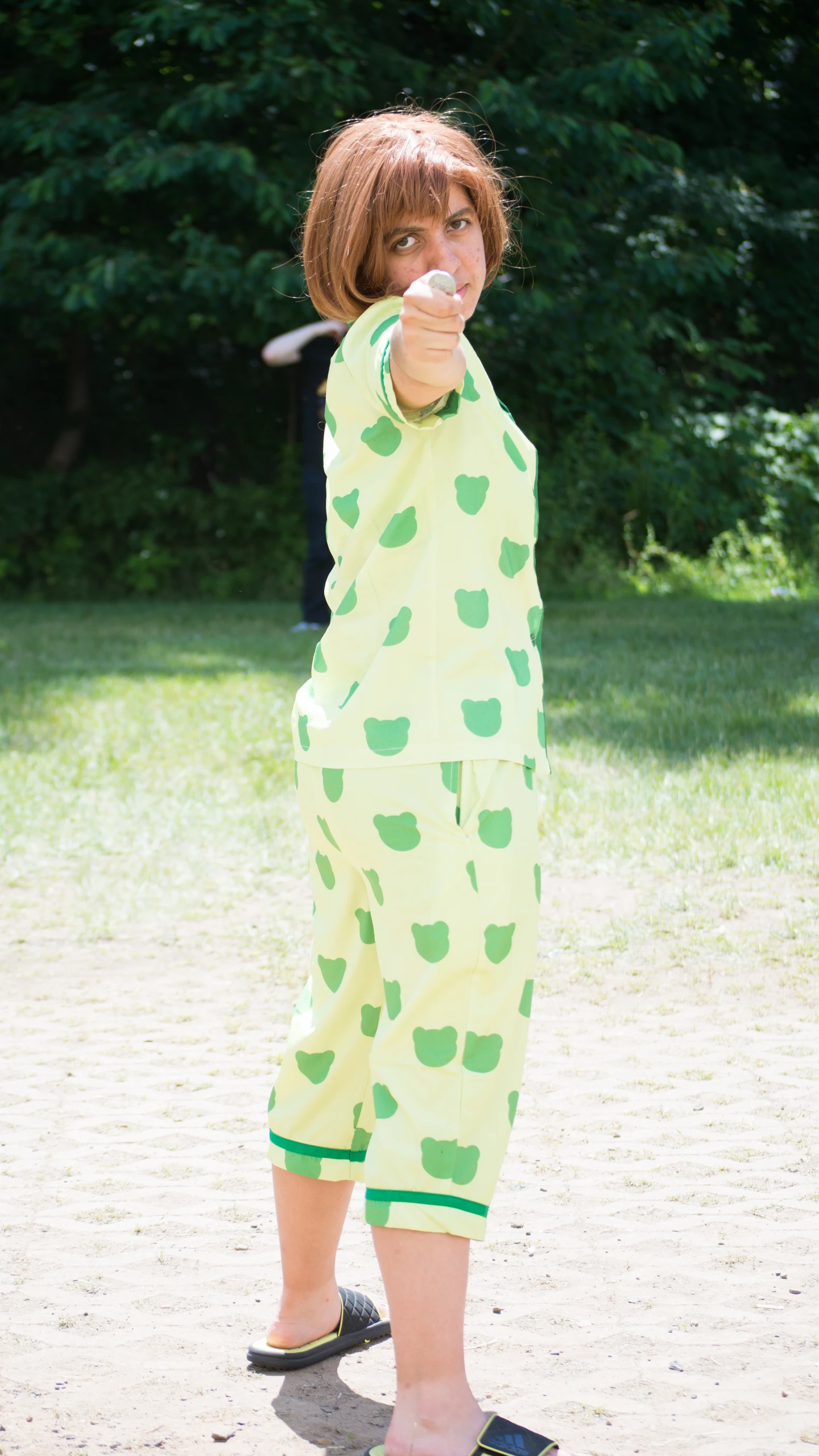 a little  in green polka dot print pajama pants about to swing at a baseball