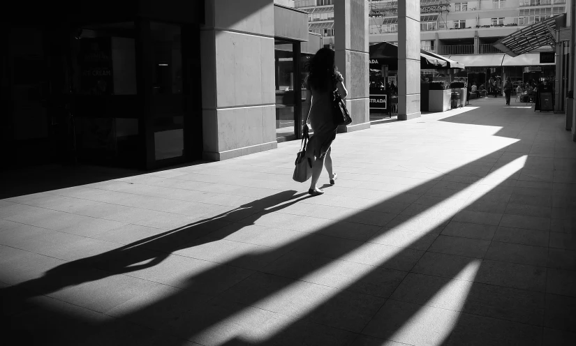 a person walking down a street holding onto a umbrella