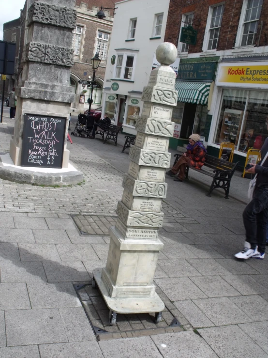 a tall white column sitting on the middle of a street