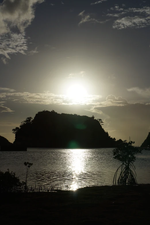 a boat floating in the water as the sun goes down