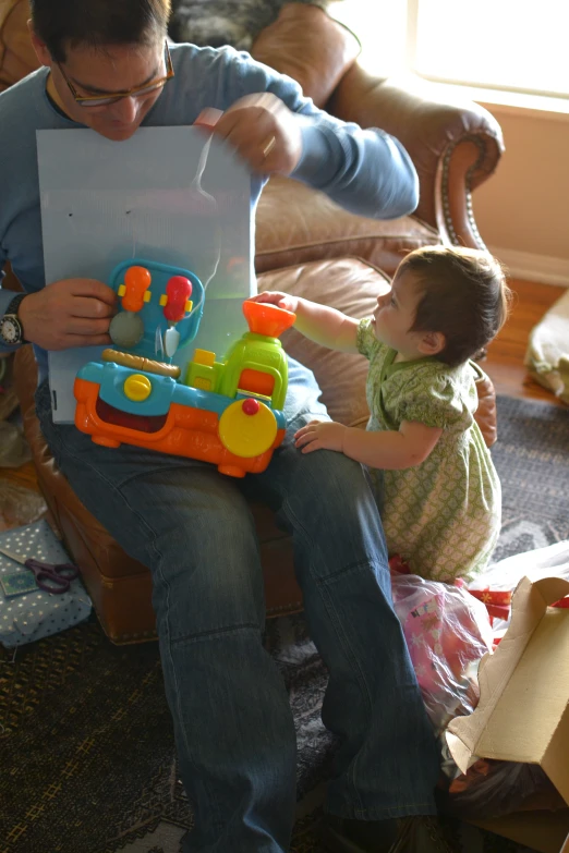 a man playing with a child and holding a toy