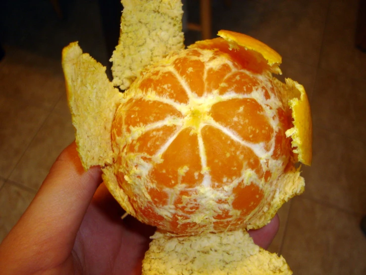 someone holding an orange with orange peel inside