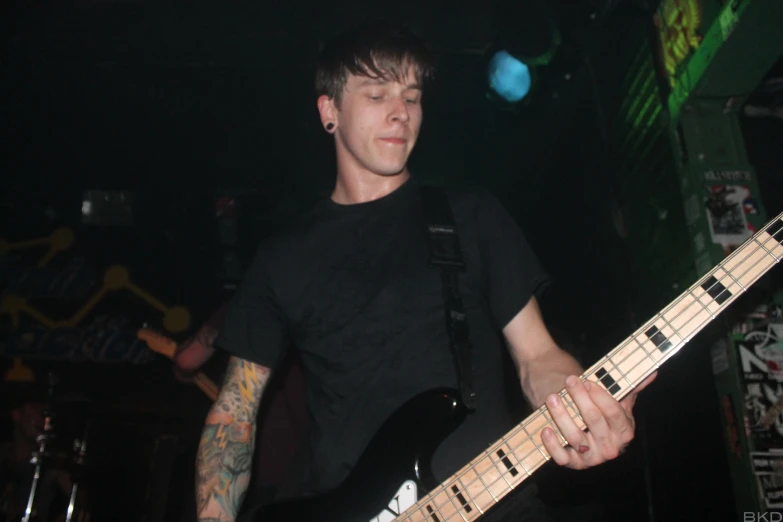 a male with a guitar and a black background