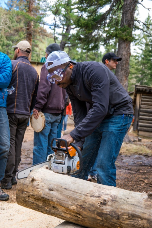 a man using a chainsaw to cut a log