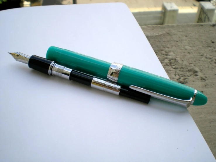 two fountain pens laying on top of each other