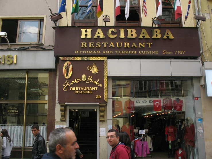 people walk outside a restaurant in an upscale city