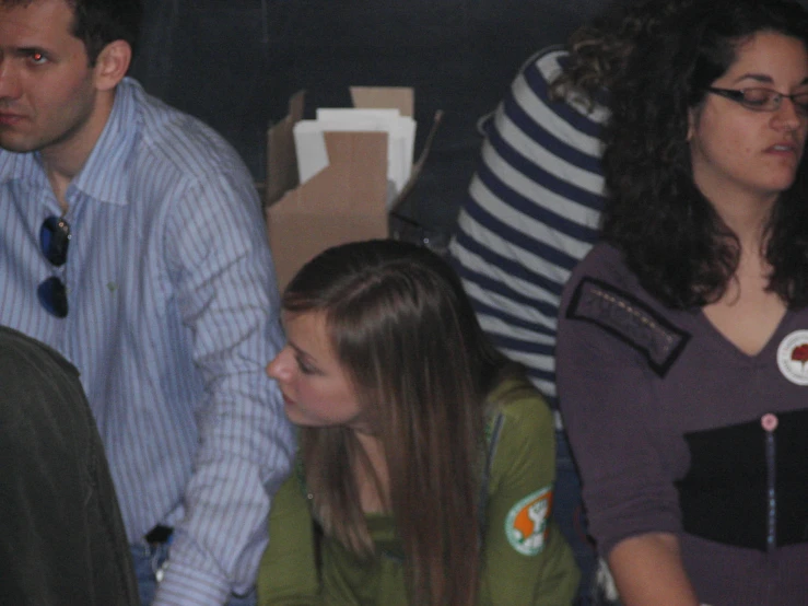 two young people sitting together and playing nintendo wii