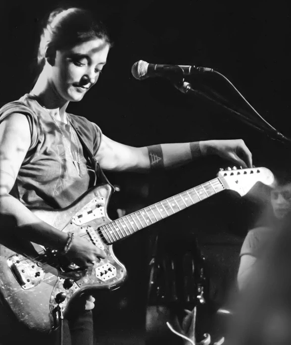 the singer plays his guitar while standing in front of a microphone