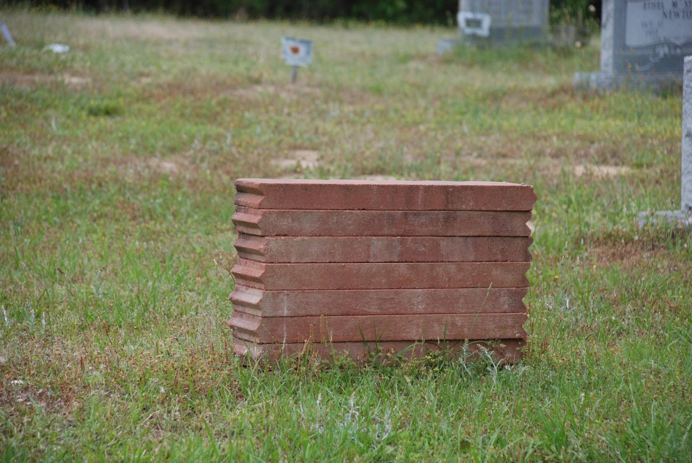 a pile of bricks sitting on top of a lush green field