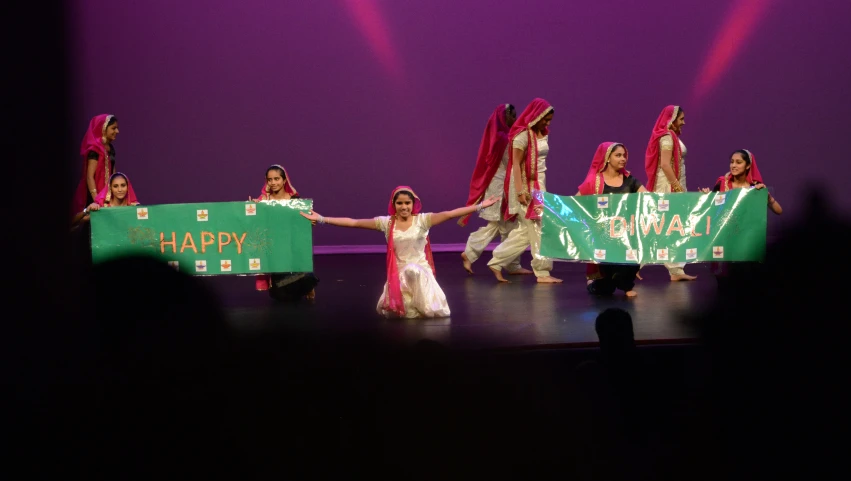 several people on stage holding onto a happy new year sign