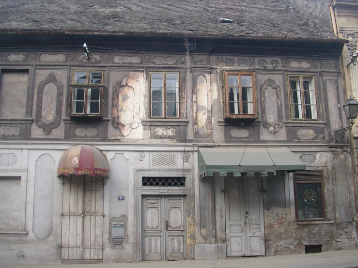 a large white building with two stories and an awning