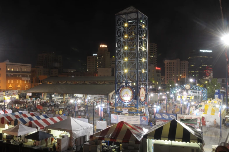 a carnival with rides and people on the street at night