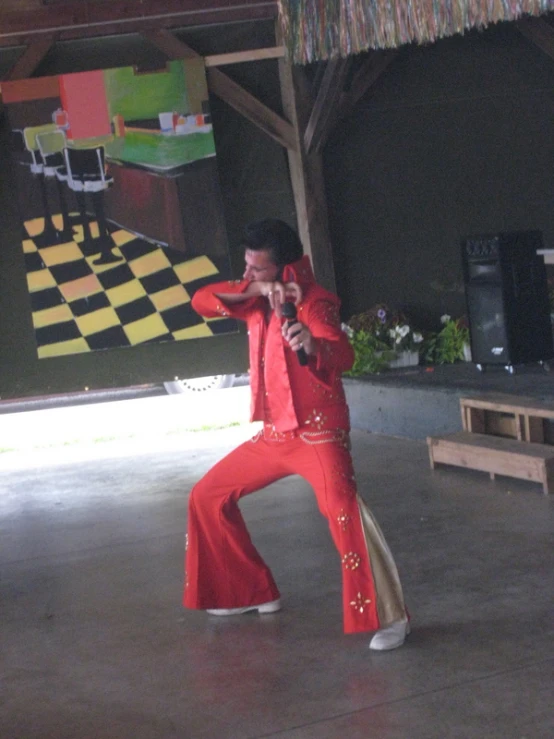 a man dressed in red is dancing outside