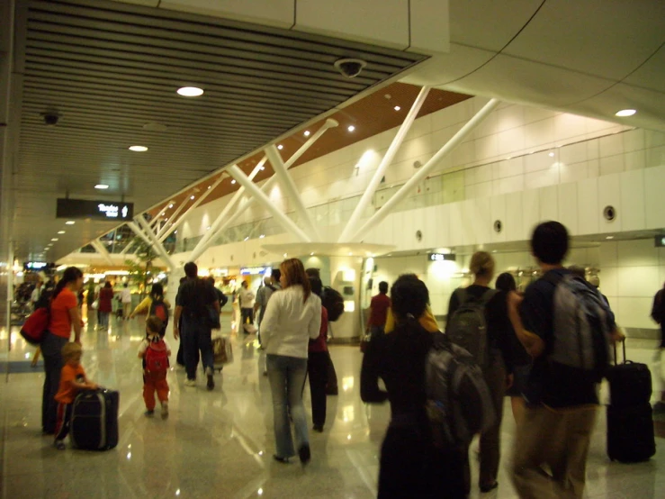 a group of people walking through a terminal with luggage