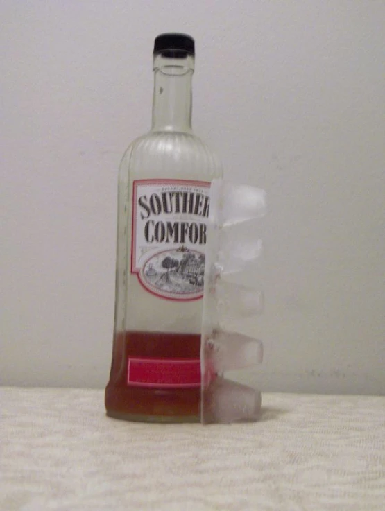 an empty bottle with ice inside sitting on the floor