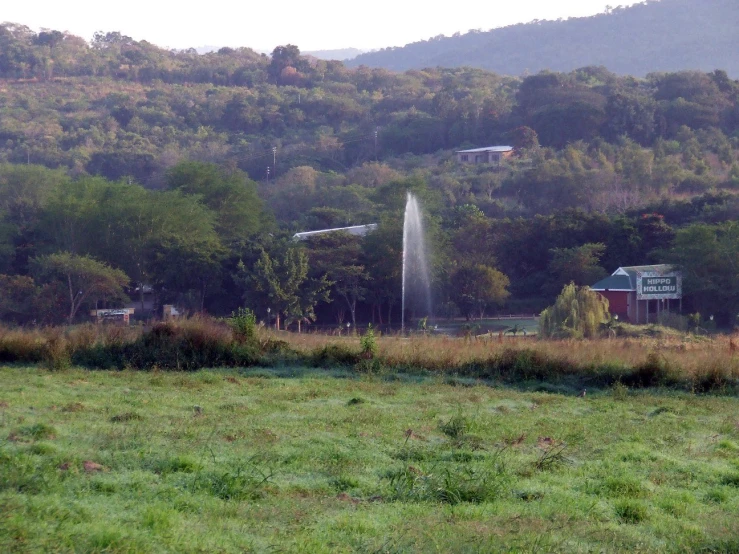 a water fountain in the middle of a field