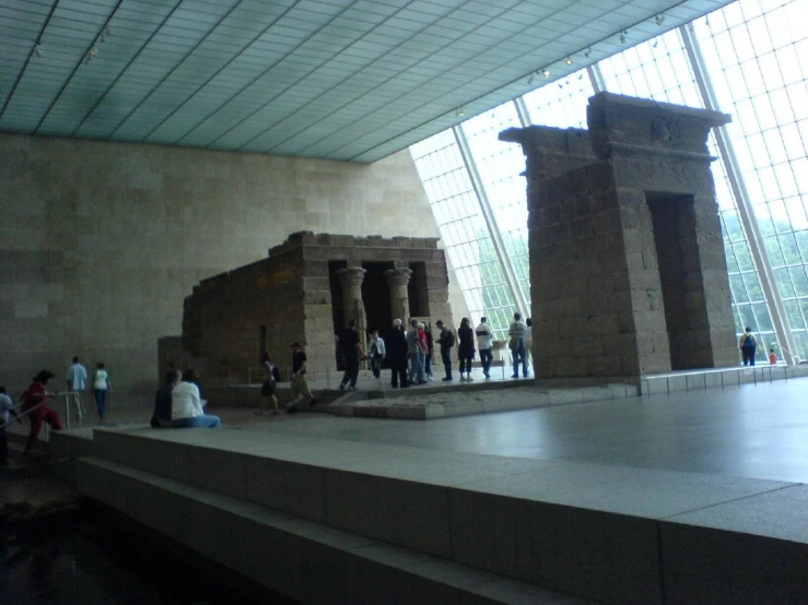 a very large room with some statues and people walking around