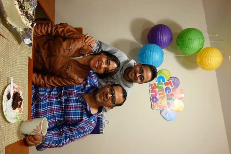 a family sitting at the table for birthday cake