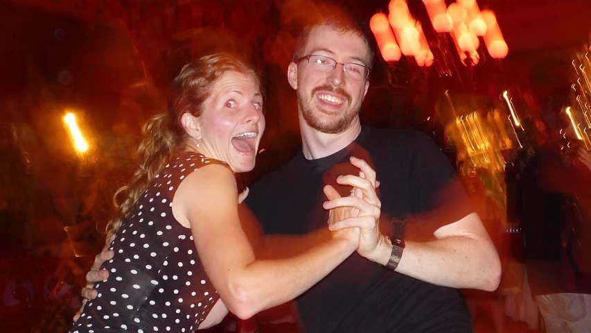 two people dancing in a nightclub with their arms around each other