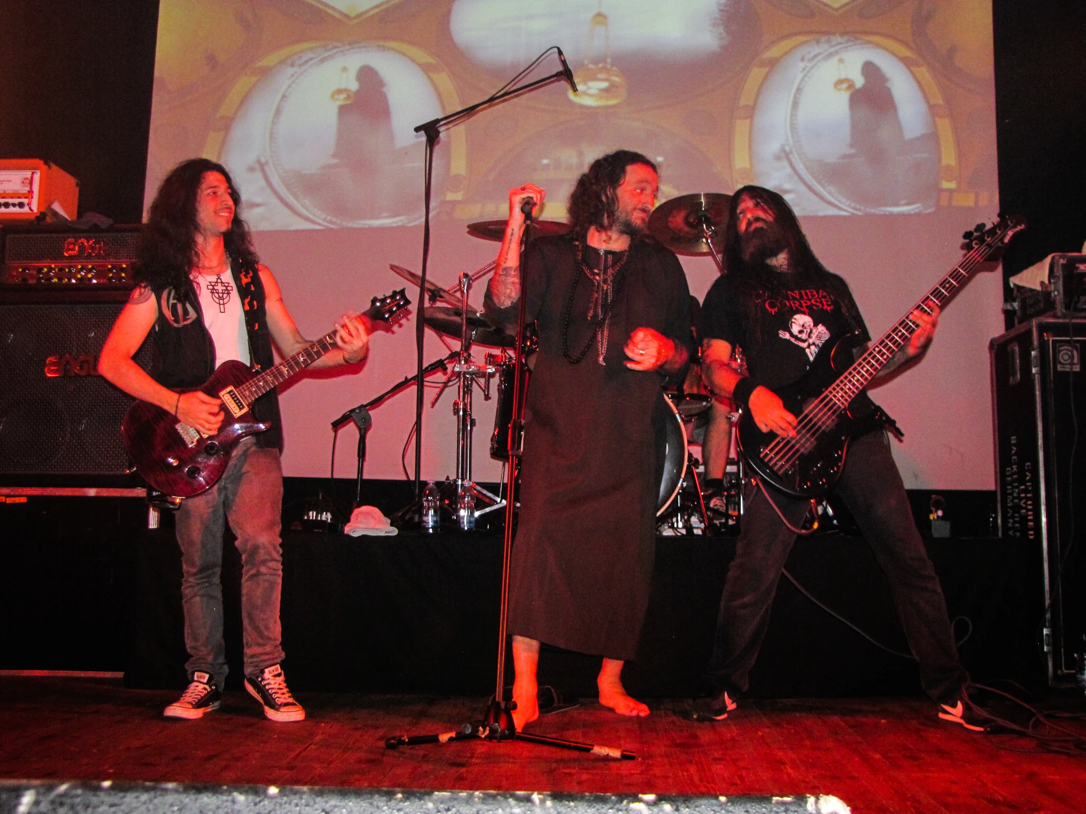 a group of men with guitars singing on stage