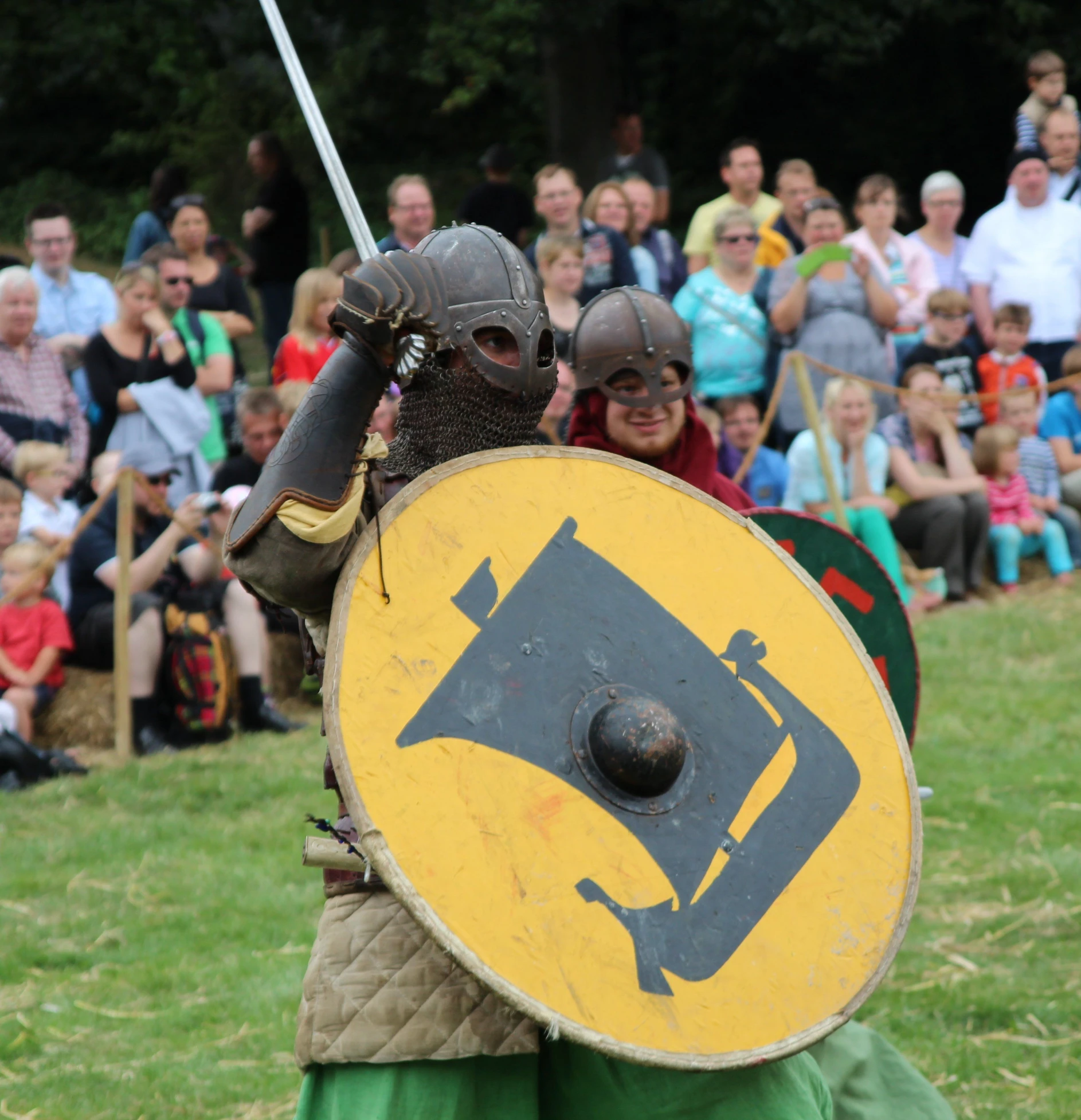 a man with a large shield in front of a crowd