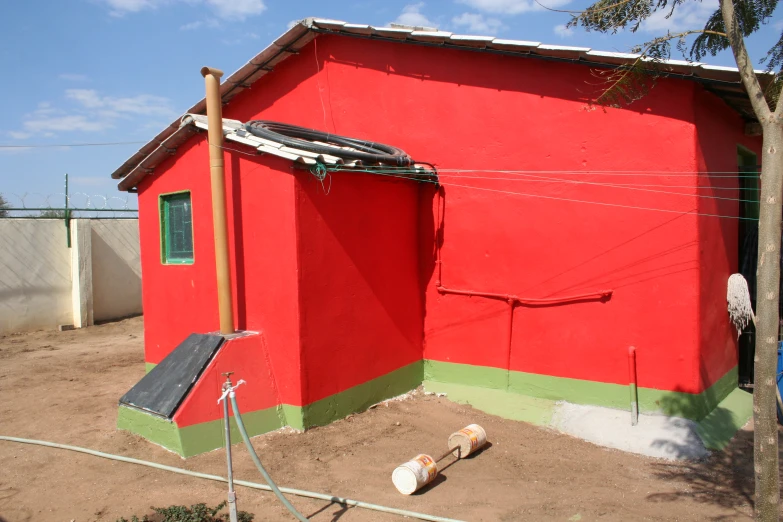 a red building with two pieces of wood near it