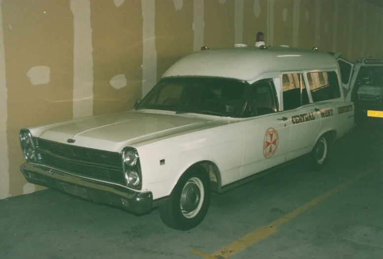 a white van and an ambulance sitting in a garage