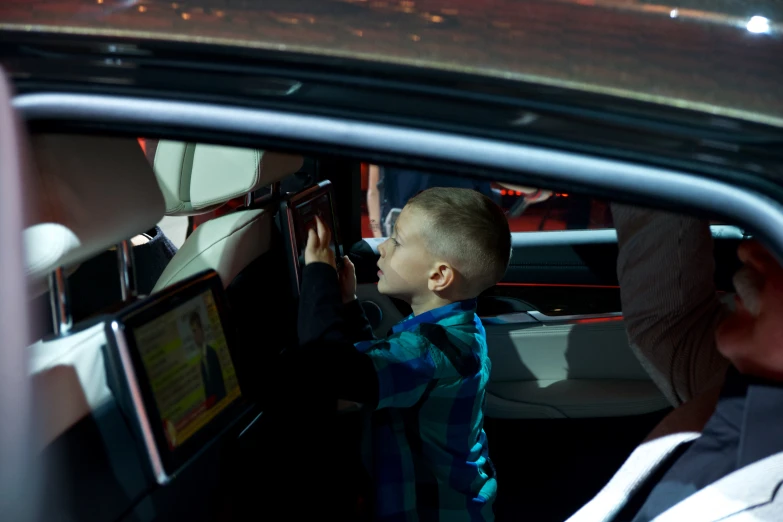 there is a young child inside a car holding a display