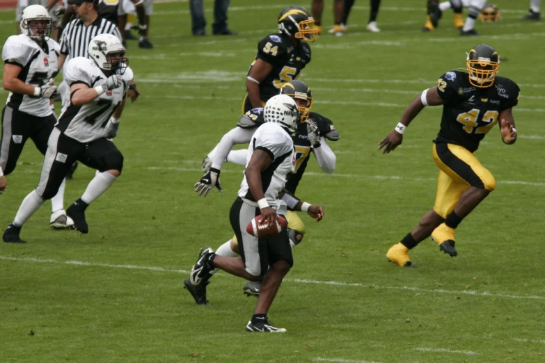 several football players on field and one is rushing the ball