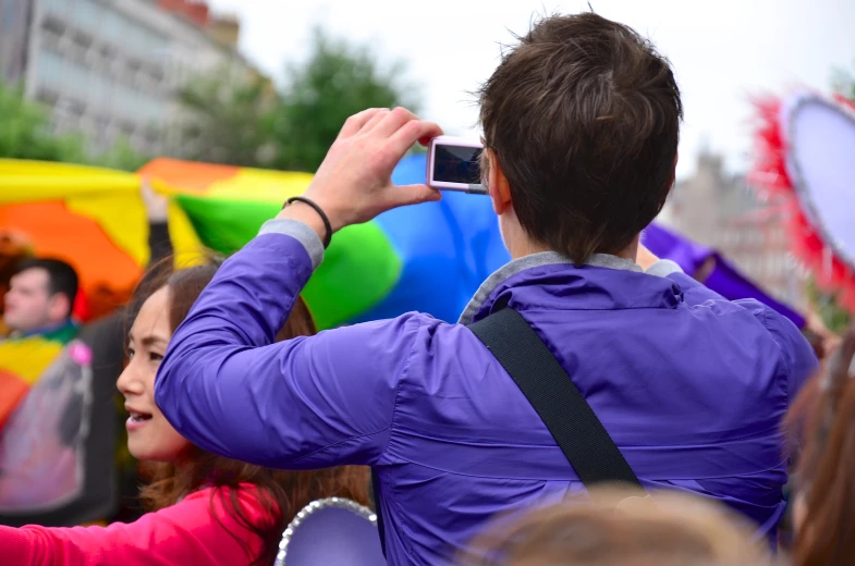 a group of people with balloons and a cellphone