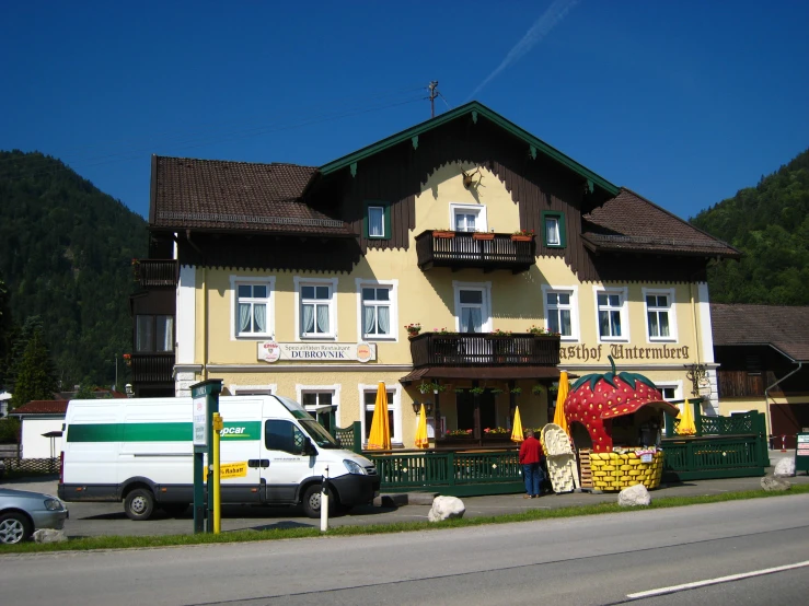 an elegant building with two story is painted yellow and has decorations on the front