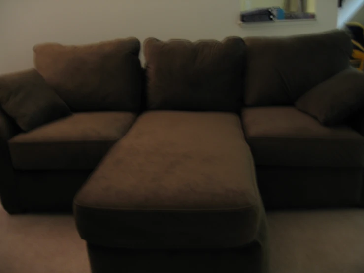 a couch and footstool is arranged in a living room