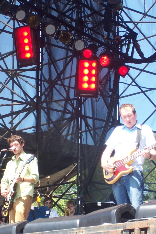 two guys are playing music on stage under red light signals