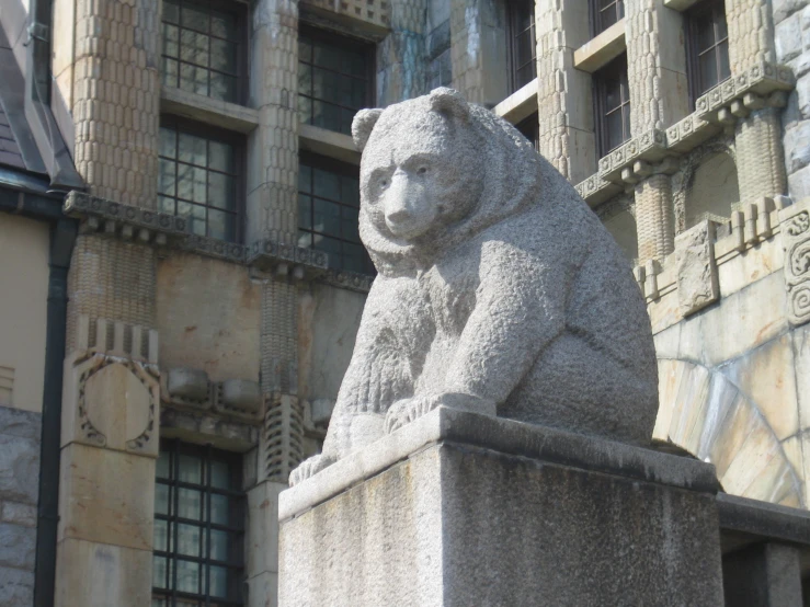 a stone statue of a bear in front of an old building